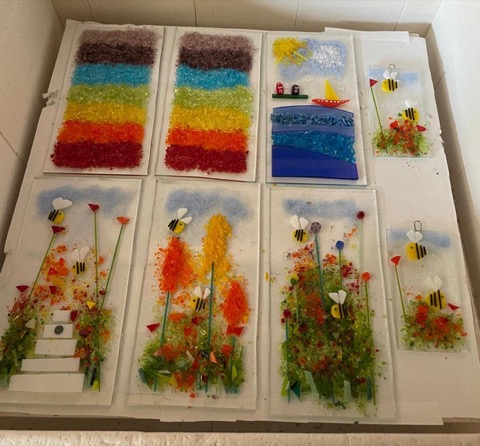 Collection of fused glass panels including rainbows, seascapes and bees
