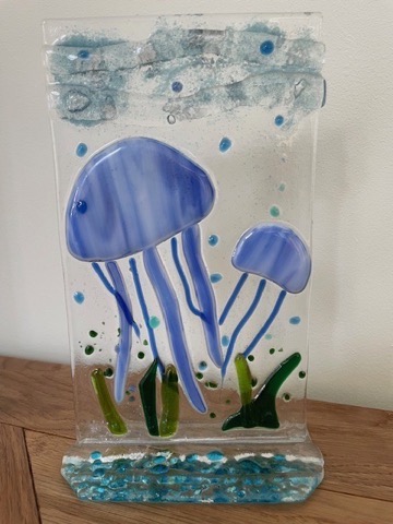 Standing fused glass panel with blue jellyfish and green seaweed